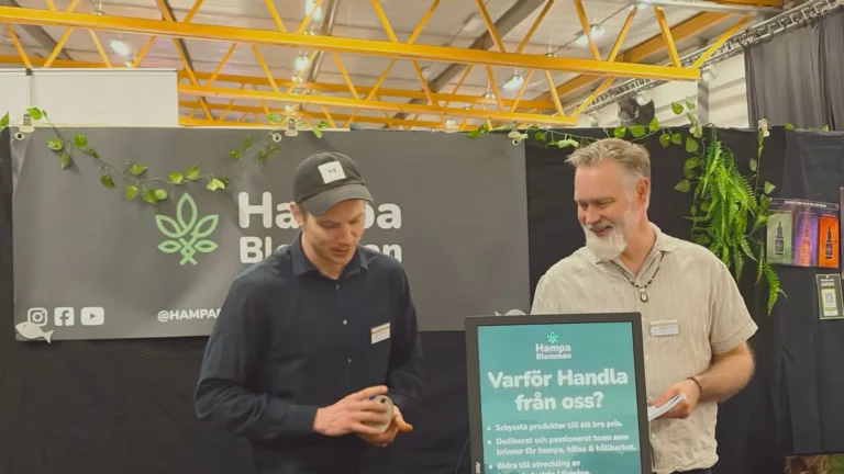 vå utställare i Hampablommans monter på Harmoni Expo våren 2026, med banderoll och skylt “Varför handla från oss?”