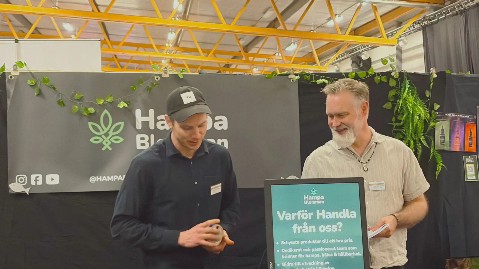 vå utställare i Hampablommans monter på Harmoni Expo våren 2026, med banderoll och skylt “Varför handla från oss?”